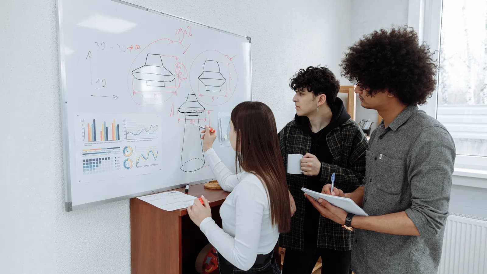 Entrepreneurs standing around a growth chart, brainstorming ideas in a startup office